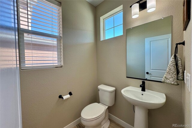 bathroom with a wealth of natural light and toilet