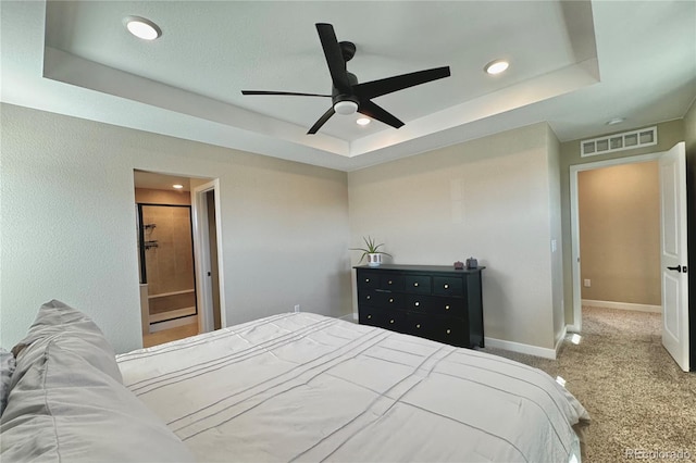 carpeted bedroom featuring ceiling fan and a raised ceiling