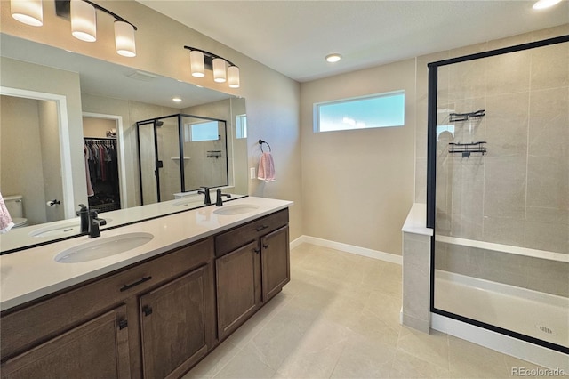 bathroom with tile patterned floors, vanity, and tiled shower