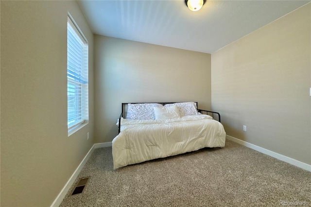 carpeted bedroom featuring multiple windows