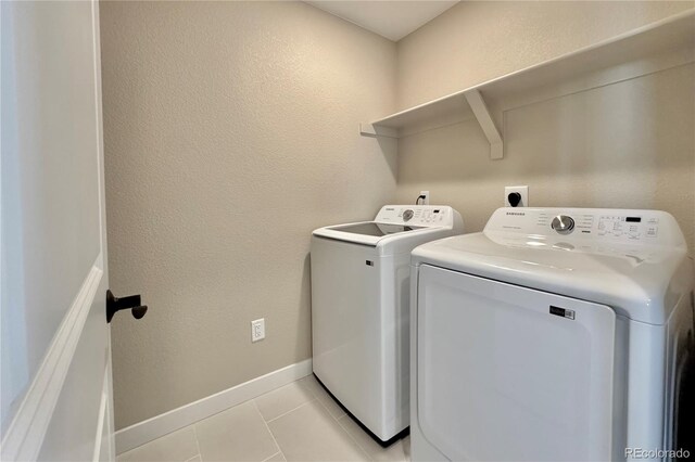 laundry area with light tile patterned flooring and washer and clothes dryer