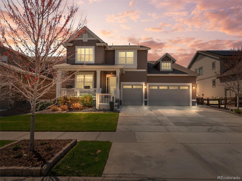 1880 Marquette Dr, Erie, CO 80516 - craftsman-style home featuring a porch, a garage, fence, a front lawn, and driveway