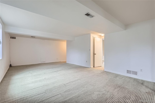 empty room with visible vents, baseboards, and light carpet