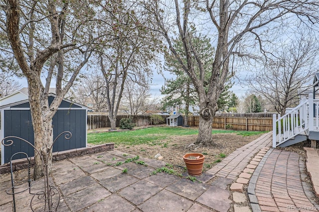 view of yard featuring a patio, an outdoor structure, a storage shed, and a fenced backyard