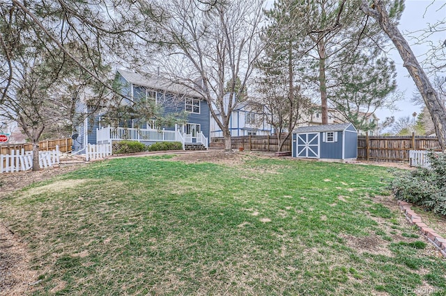 view of yard featuring a storage unit, a fenced backyard, and an outdoor structure