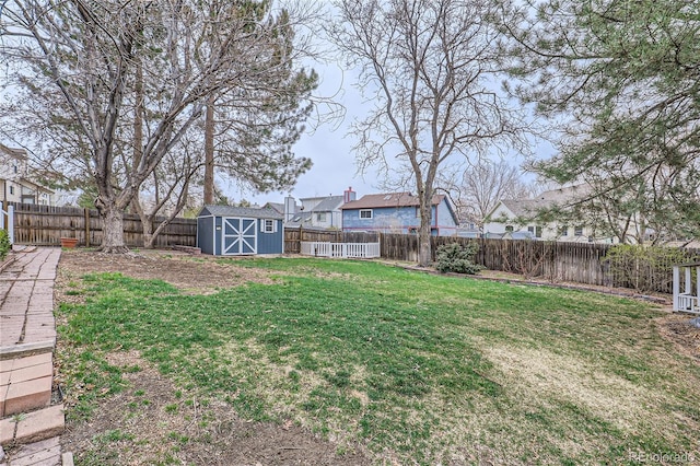 view of yard featuring an outbuilding, a fenced backyard, and a storage unit