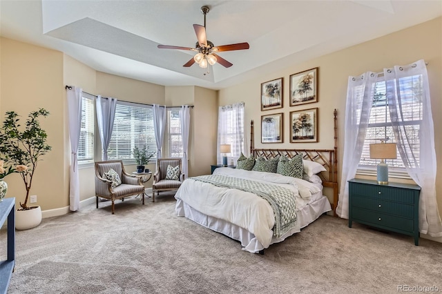 bedroom with carpet floors, a raised ceiling, ceiling fan, and baseboards