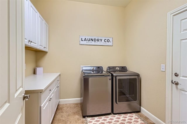 washroom with cabinet space, baseboards, and independent washer and dryer