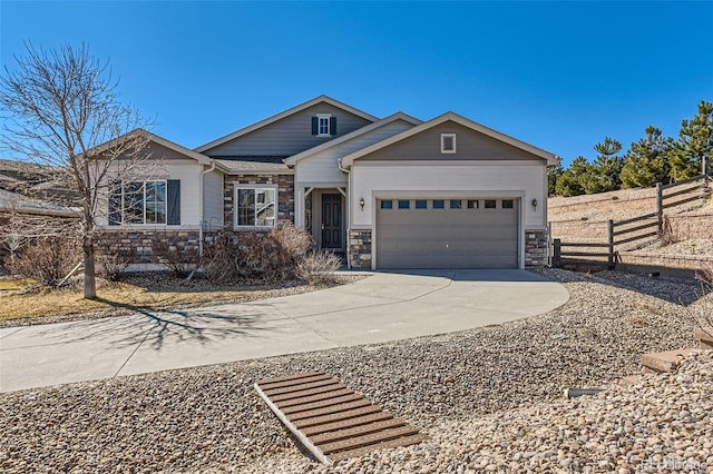 view of front of home with a garage, stone siding, fence, and driveway