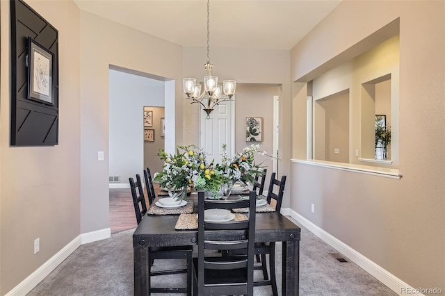 dining space with carpet floors, visible vents, baseboards, and a notable chandelier