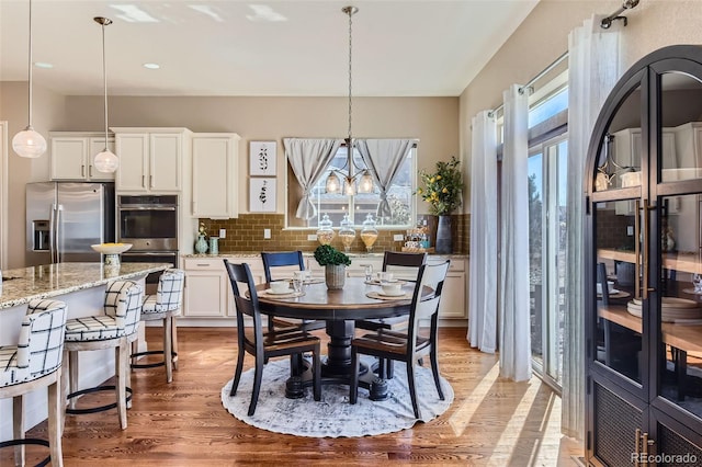 dining area with a chandelier and light wood finished floors