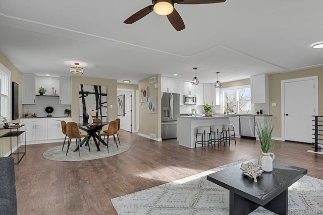 living room with ceiling fan, dark hardwood / wood-style flooring, and sink