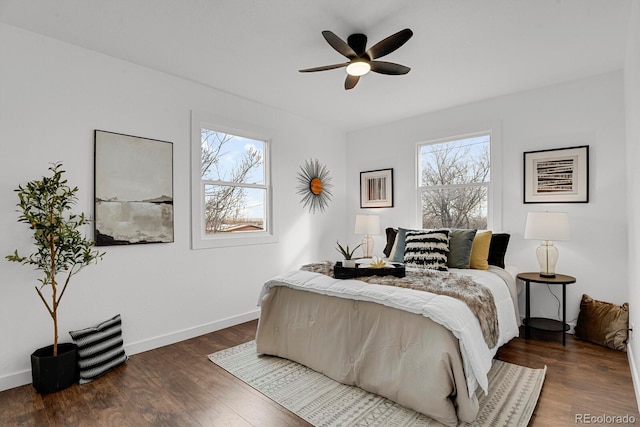 bedroom with multiple windows, ceiling fan, and dark hardwood / wood-style flooring