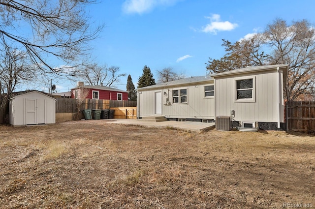 back of property with central air condition unit and a storage shed