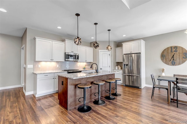 kitchen with baseboards, a sink, white cabinetry, and stainless steel appliances