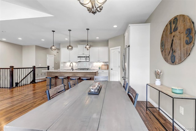 dining space with recessed lighting, an inviting chandelier, and dark wood-style floors