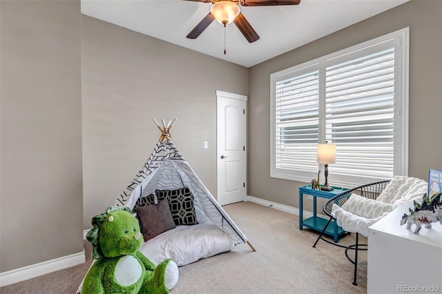 recreation room with carpet floors, ceiling fan, and baseboards