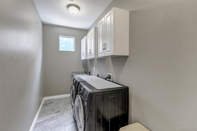 clothes washing area with separate washer and dryer, baseboards, cabinet space, and marble finish floor