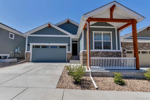 11494 Colony Loop, Parker, CO 80138 - view of front of house featuring covered porch, an attached garage, driveway, and stone siding