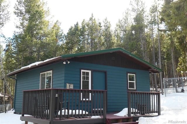 view of snowy exterior with a wooden deck