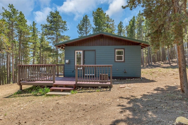 rear view of property featuring a wooden deck