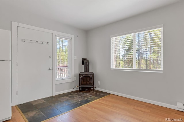 foyer with a wood stove and dark hardwood / wood-style flooring