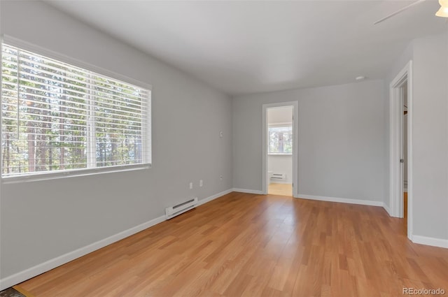 unfurnished room featuring light hardwood / wood-style flooring and baseboard heating