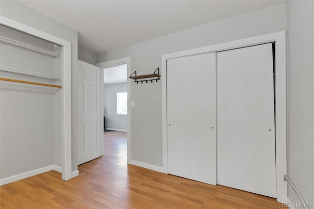 unfurnished bedroom featuring wood-type flooring and a closet