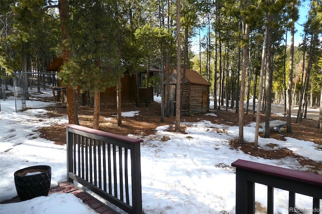 snowy yard featuring a shed