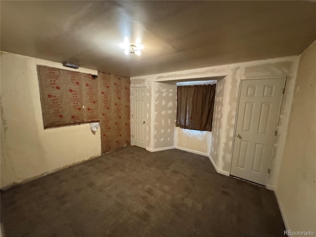 unfurnished room featuring dark carpet