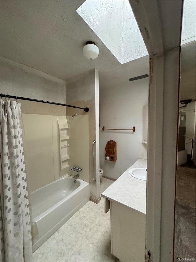 full bathroom with vanity, shower / bath combo with shower curtain, toilet, and a skylight