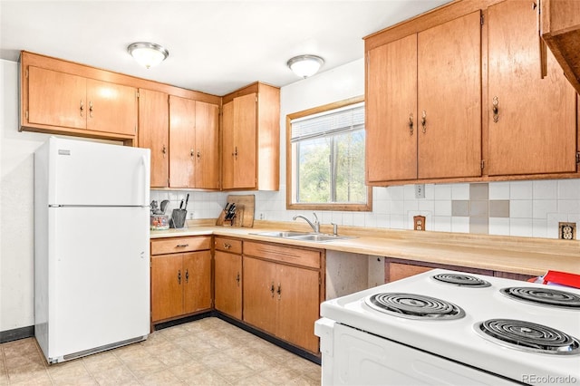 kitchen with light countertops, tasteful backsplash, a sink, and white appliances