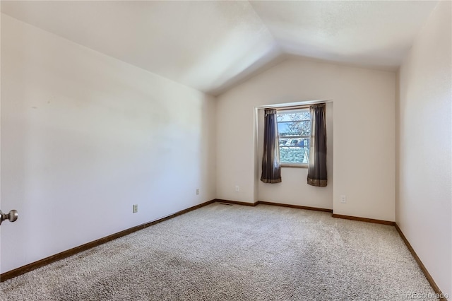 spare room featuring lofted ceiling and carpet flooring