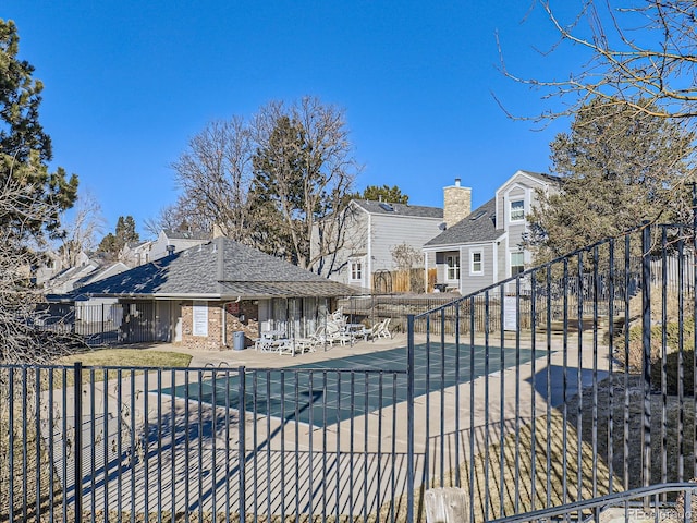 rear view of property featuring a patio and a community pool