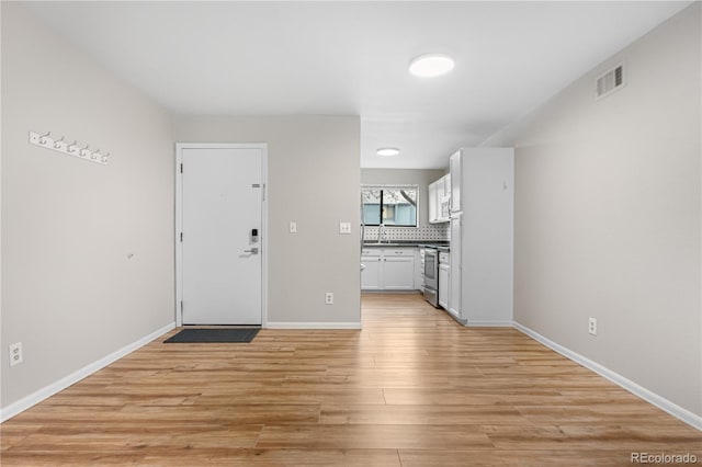 3656 S Depew St Unit 102, Denver, CO 80235 - foyer with light wood-style floors and baseboards