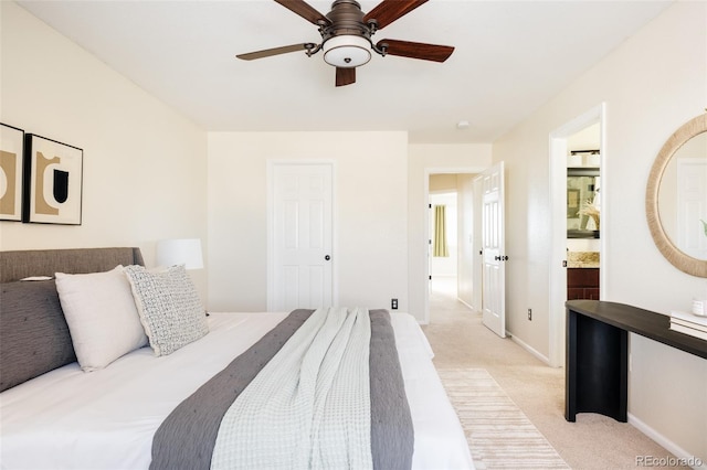 bedroom featuring light colored carpet, ensuite bath, and ceiling fan