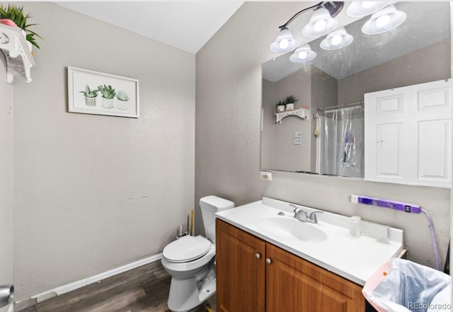 full bathroom with vanity, toilet, curtained shower, wood finished floors, and baseboards