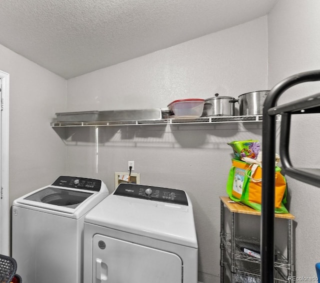 laundry area with washing machine and clothes dryer, laundry area, and a textured ceiling