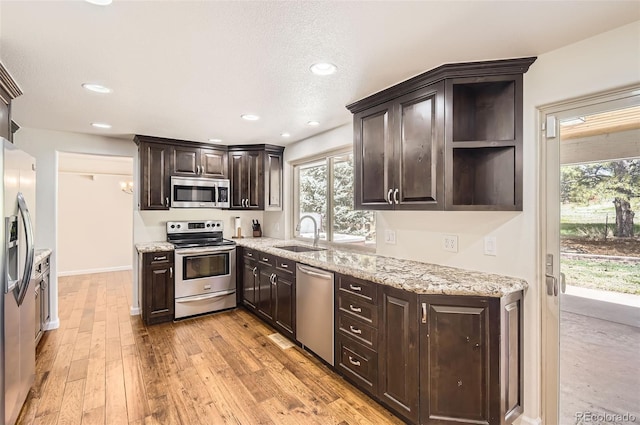 12454 Antelope Trl, Parker, CO 80138 - kitchen featuring appliances with stainless steel finishes, dark brown cabinetry, healthy amount of natural light, light stone counters, and recessed lighting