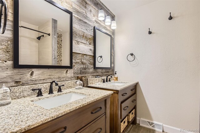 12454 Antelope Trl, Parker, CO 80138 - full bath featuring two vanities, a tile shower, wood finished floors, and decorative backsplash