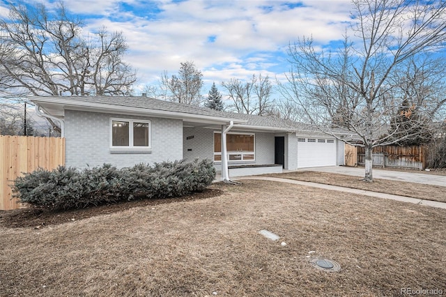 ranch-style home with an attached garage, driveway, fence, and brick siding