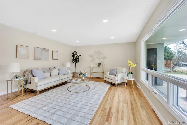 living room with recessed lighting, baseboards, and light wood finished floors