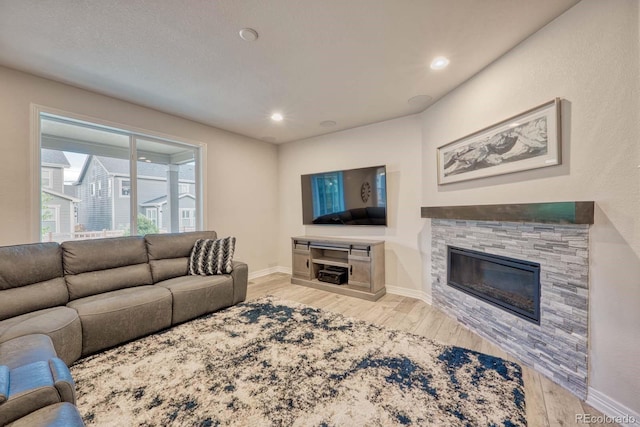 living room featuring light wood-type flooring and a fireplace