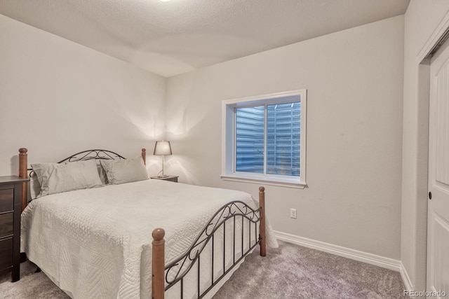 bedroom featuring a textured ceiling, carpet flooring, and a closet