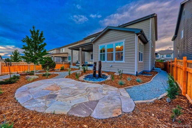 back house at dusk with a patio area