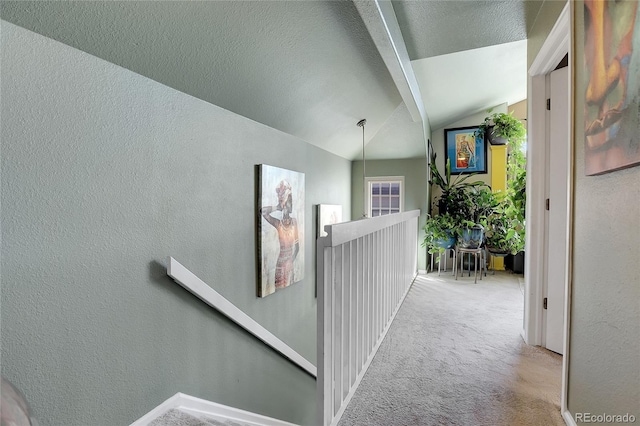 corridor with vaulted ceiling and light colored carpet