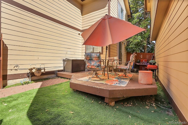 wooden terrace featuring a lawn