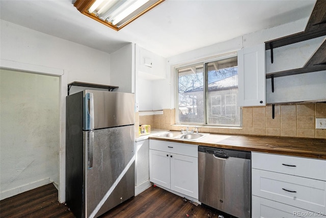 kitchen featuring a sink, stainless steel appliances, open shelves, and white cabinetry