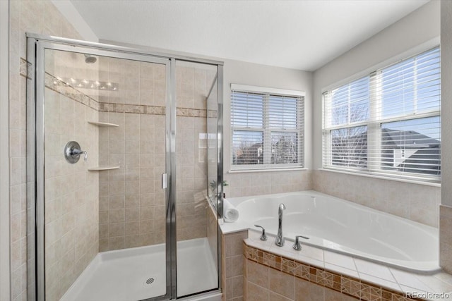 bathroom with a shower stall and a bath