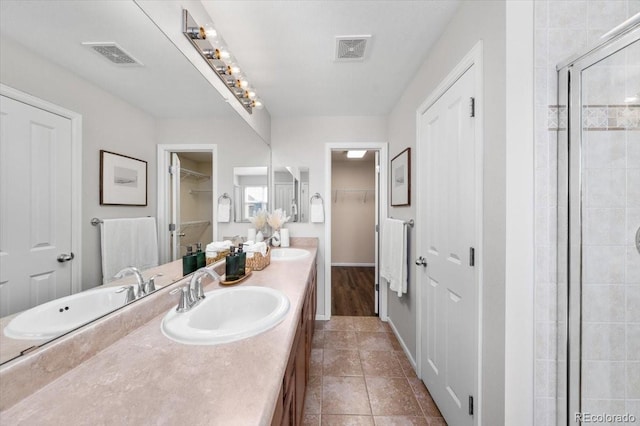 full bathroom with a spacious closet, a sink, and visible vents